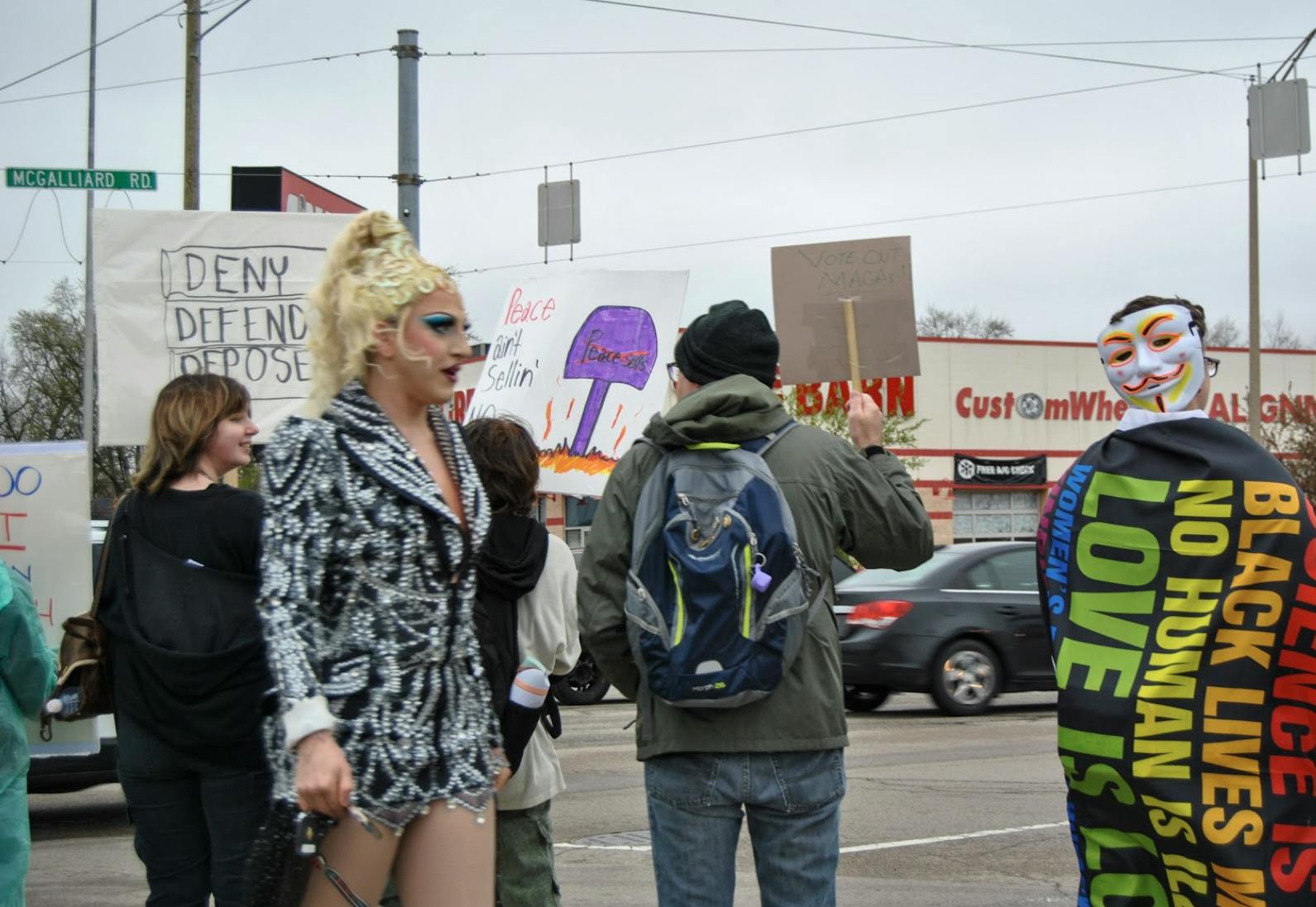 Drag queen Aura Aurora walks amongst protesters. 