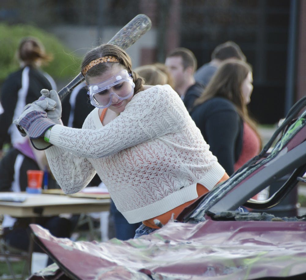 Jennifer Hughes, a freshman respiratory therapy major, hits a car during the Smash Bash hosted by the University Program Board on April 22 at the University Green. DN PHOTO BREANNA DAUGHERTY