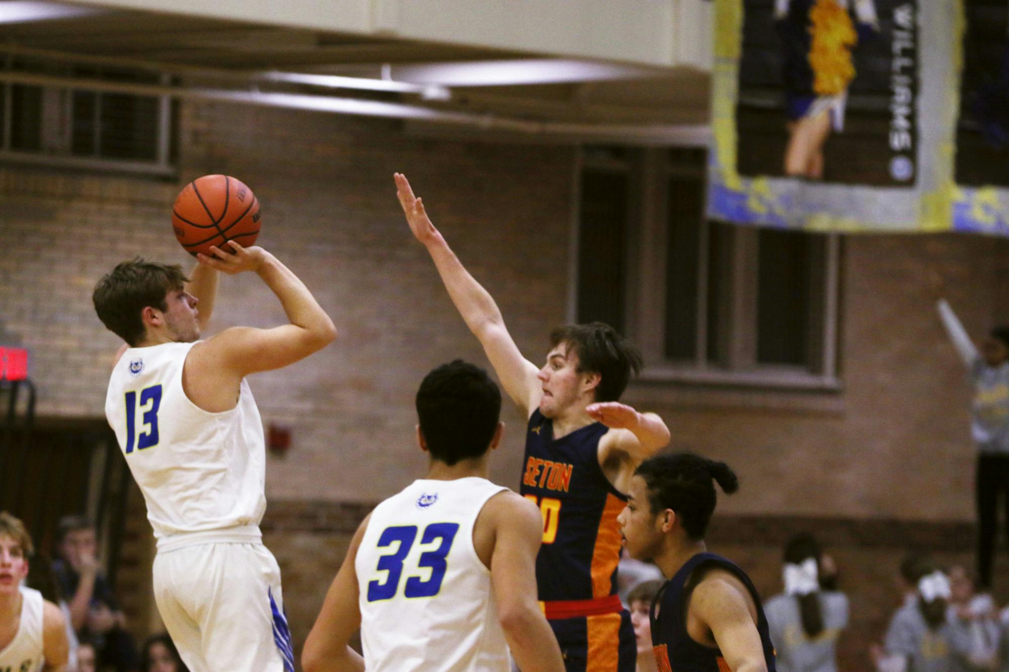 Senior Connor Mckibben attempts to shoot a ball over a Seton Catholic defender Jan. 27 at Ball Gymnasium. Zach Carter, DN