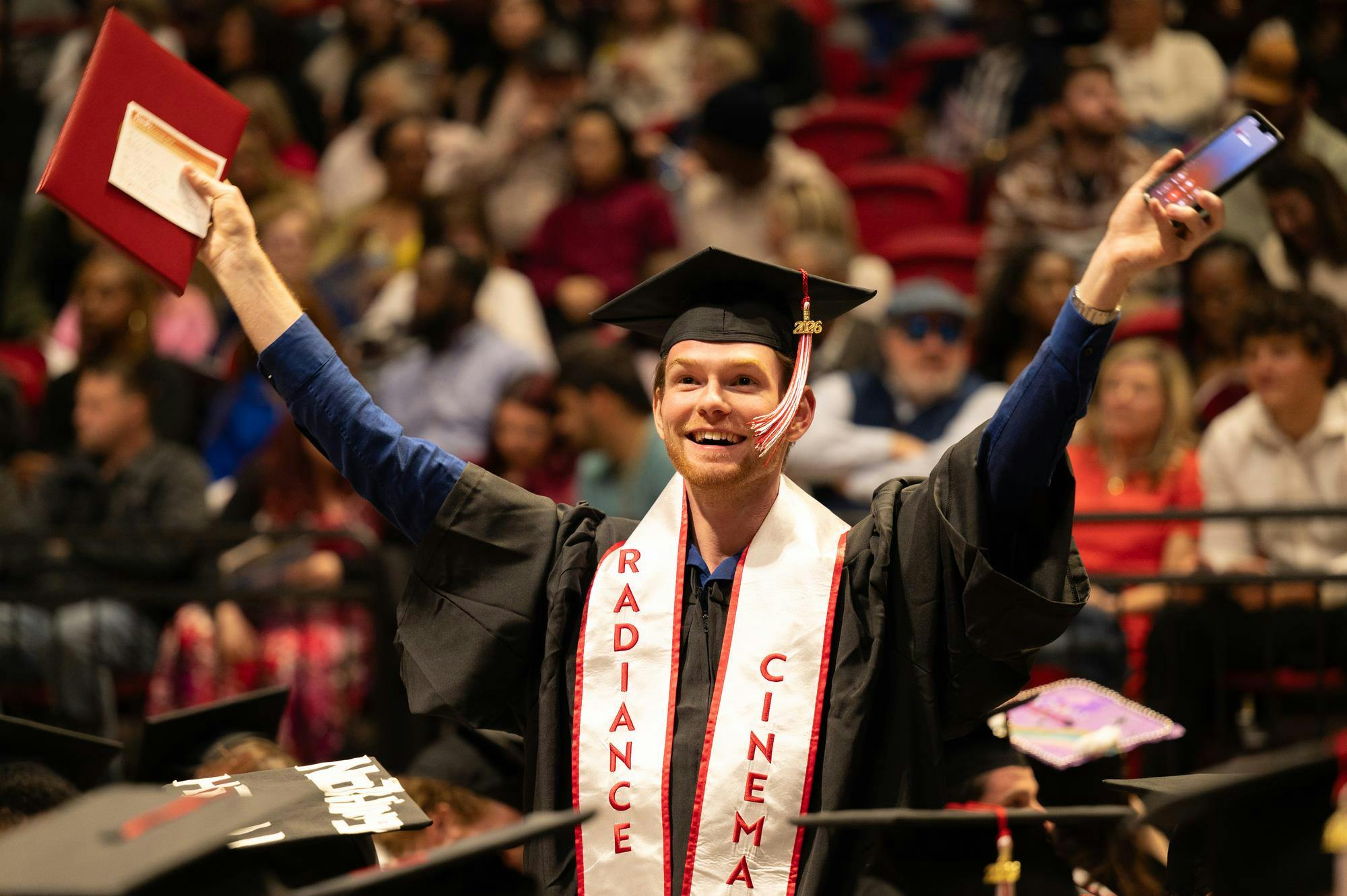Ball State graduate waves their arms to get the attention of their loved ones before the start of the 2026 Spring Commencement Ceremony for the Miller College of Business and the College of Communication, Information, and Media May 2 in Worthen Arena. Kadin Bright, DN