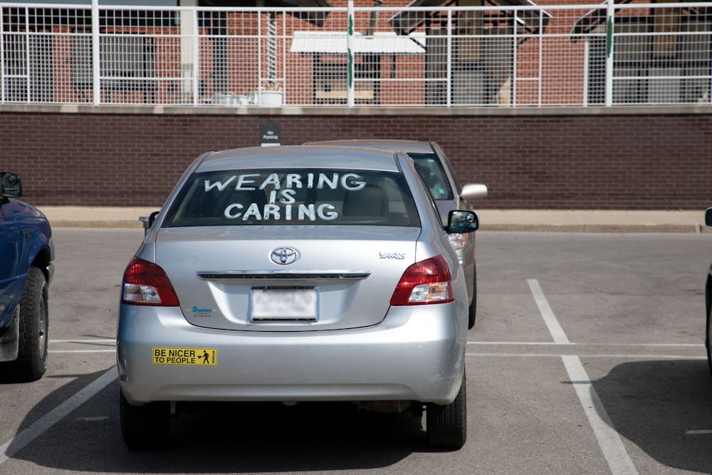 A car sits parked with &quot;Wearing Is Caring&quot; painted in the window Aug. 29 near the Arts and Journalism building. On AUg. 28, Ball State President Geoffrey Mearns sent out an email to students about COVID-19 cases at Ball State. Charles Melton, DN