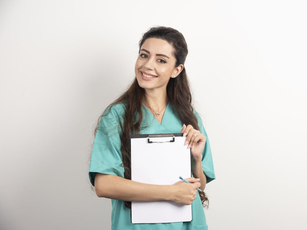 Young female medical employee holding medical records.