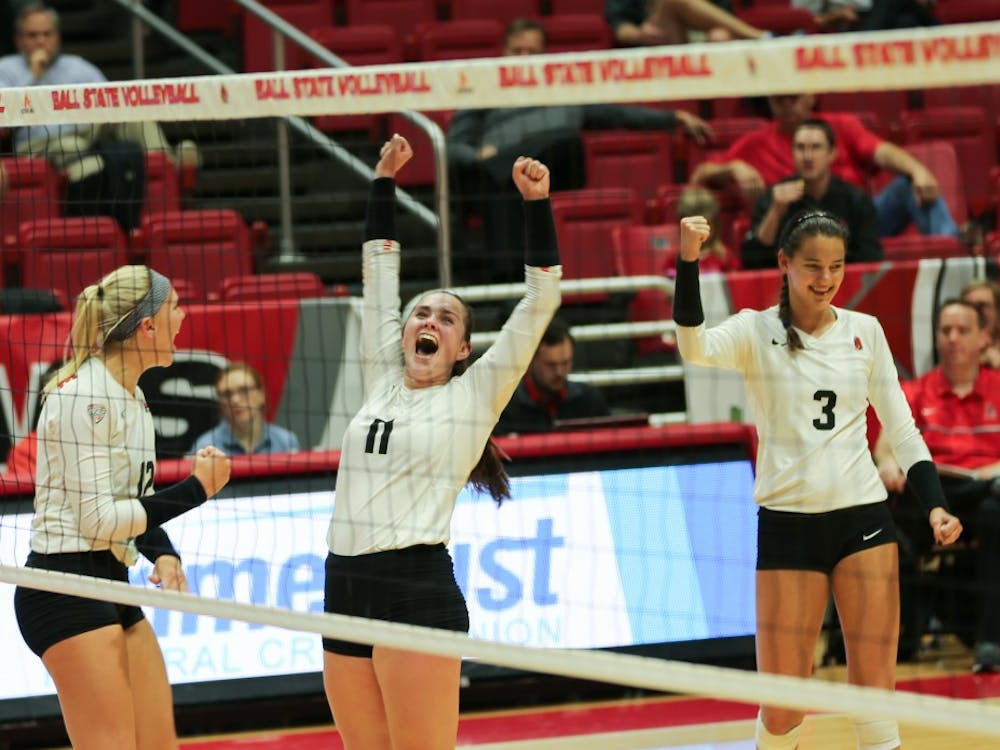 Sophomores Amber Seamen and Sydnee Vanbeek and junior Brooklyn Goodsel celebrate after getting a point against Toledo on Nov. 2 at John E. Worthen Arena. They won the game 3-1. Elliott DeRose, DN