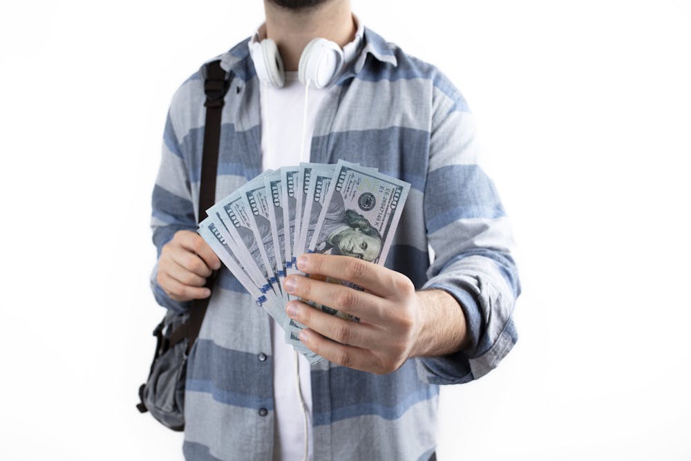 Student with money and shoulder bag. school financial aid, school payments, education and money concept background.