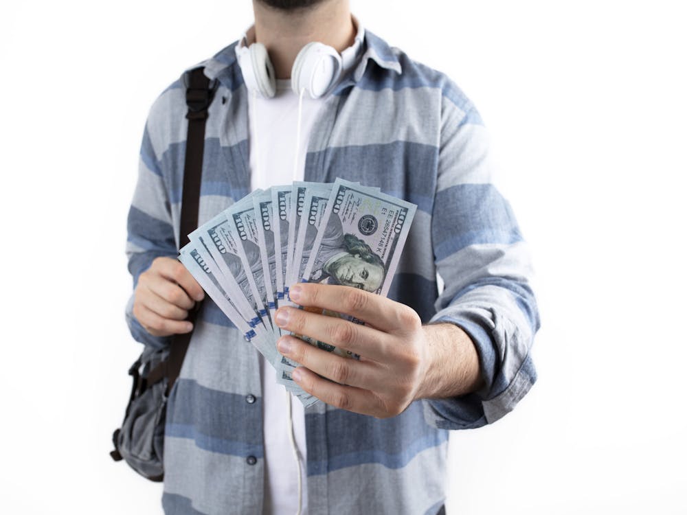Student with money and shoulder bag. school financial aid, school payments, education and money concept background.
