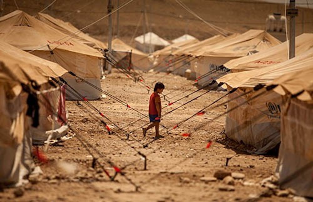 A child walks between dusty tents to look for his family in the Quru Gusik refugee camp set up near the border with Syria on Aug. 24. MCT PHOTO