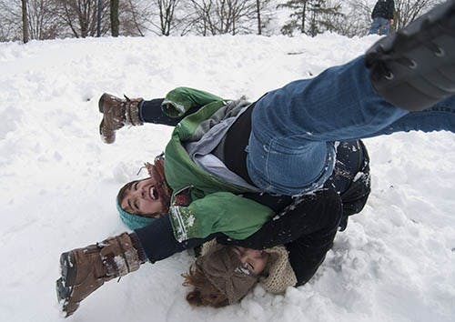 Stephanie Metzger tumbles over sophomore Kat Winton after falling off a makeshift sled.The snowstorm caused Ball State to close for two hours. DN PHOTO BOBBY ELLIS