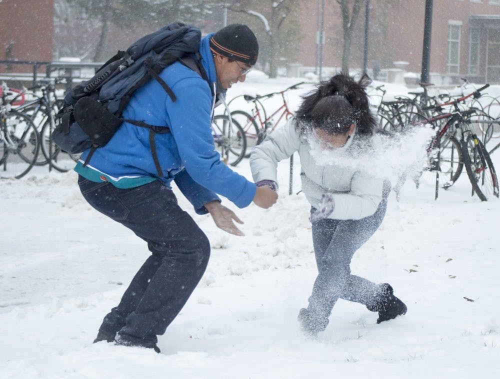 Carlos Flores and Ada Cortes play in the snow on Nov. 17 outside of Bracken Library. They are from southern Mexico and this is their first time seeing snow. DN PHOTO ALAINA JAYE HALSEY