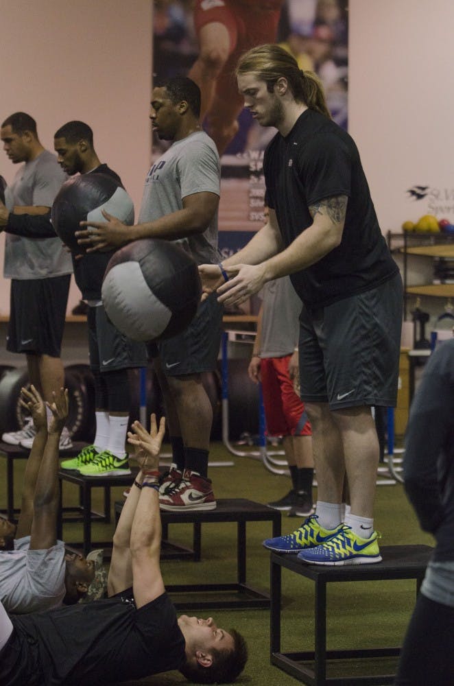 Zane Fakes drops a medicine ball to Keith Wenning as part of their warm-ups on Feb. 1 at the St. Vincent Sports Performance Center in Indianapolis, IN. Wenning and Fakes are in a program to train for the NFL Combine on Feb. 22-25DN FILE PHOTO BREANNA DAUGHERTY