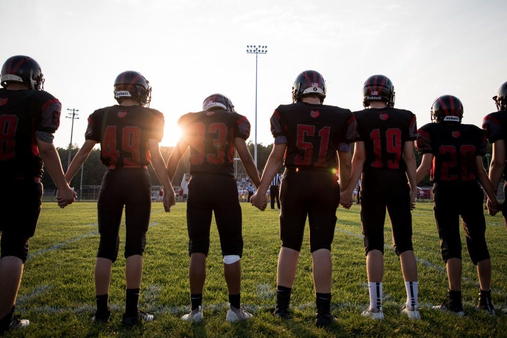 Blackford Bruins players hold hands on the sideline during the coin toss Sept. 20, 2019, in Hartford City, Indiana. The Bruins finished the regular season at 5-4. Eric Pritchett, DN