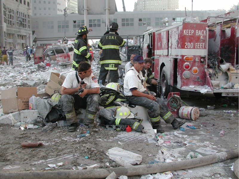 New York City firefighters sit in rubble from the collapsed towers of the World Trade Center Sept. 11, 2001. The New York City Fire Department was one of the first responders on scene when Flight 11 crashed into the north tower. U.S. Army Corps of Engineers, Photo Courtesy
