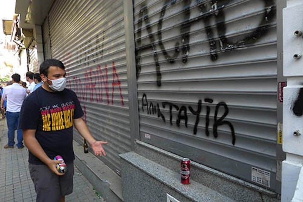 A gaffiti artist admires his work on a main pedestrian street in Istanbul, Turkey, on Saturday. Police and protestors clashed during the day in the city. MCT PHOTO
