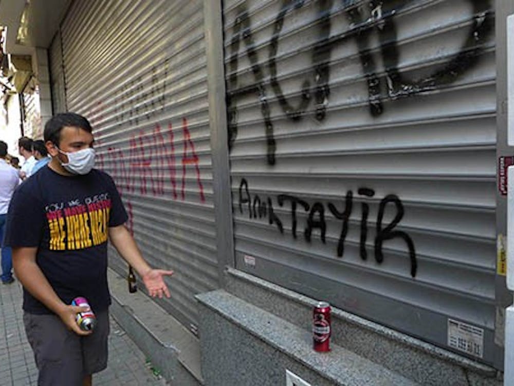 A gaffiti artist admires his work on a main pedestrian street in Istanbul, Turkey, on Saturday. Police and protestors clashed during the day in the city. MCT PHOTO