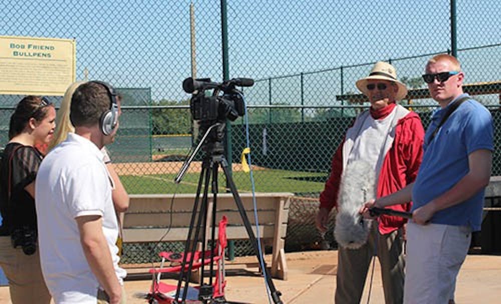 Junior Drew Bogs holds a boom mic during an interview at the Pirates Minor League Complex in Brandenton, Fla. The immersive learning group traveled to the spring training of the Pittsburgh Pirates. PHOTO COURTESY OF SUZY SMITH