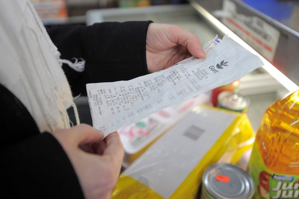 Sarah Shepard-Kneip, program specialist at AARP Maryland, checks her receipt after she shops for groceries at Lee's Food Market in the Sandtown-Winchester community in Baltimore, Jan. 28, 2011. The shopping experiment, conducted at an inner-city neighborhood market, uses $30 to see what food stamp items can be purchased. MCT