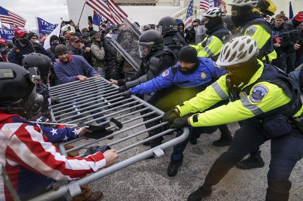 Trump supporters try to break through a police barrier and into the House Chamber, Wednesday, Jan. 6, 2021, at the Capitol in Washington. As Congress prepared to affirm President-elect Joe Biden's victory, thousands of people gathered to show their support for President Donald Trump and his claims of election fraud.(AP Photo/John Minchillo)