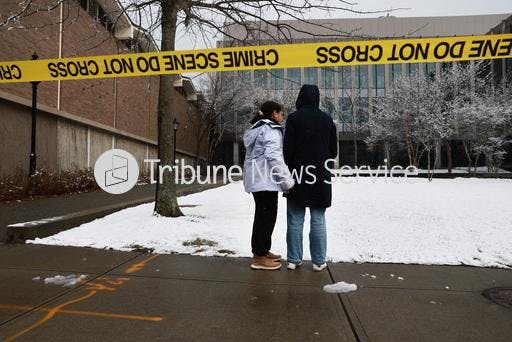 PROVIDENCE, RHODE ISLAND - DECEMBER 14: People pause outside of the engineering and physics building at Brown University, the site of a mass shooting yesterday that left at least two people dead and nine others injured, on December 14, 2025 in Providence, Rhode Island. A suspect in the shooting was detained overnight at a hotel in a nearby community following a manhunt across the prestigious university and the greater Providence area. The shooting took place around 4 p.m. on Saturday as students were preparing for exams and the holiday break. (Photo by Spencer Platt/Getty Images)
