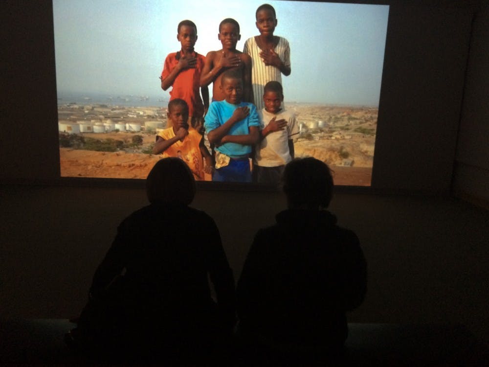 <p>Margie Frank and Sigi Koehler watch the film, "Muxima" at the Fractured Narratives Exhibit at the David Owsley Museum of Art. The film captures images of the African country, Angola and its inhabitants. DN PHOTO BY DANIELLE GRADY</p>