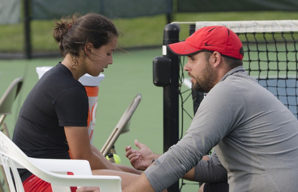 Assistant coach Viktor Maksimcuk talks to sophomore Rosalinda Calderon after her singles match against Butler for the Fall Dual on Sept. 20 at the Cardinal Creek Tennis Center. DN PHOTO BREANNA DAUGHERTY 