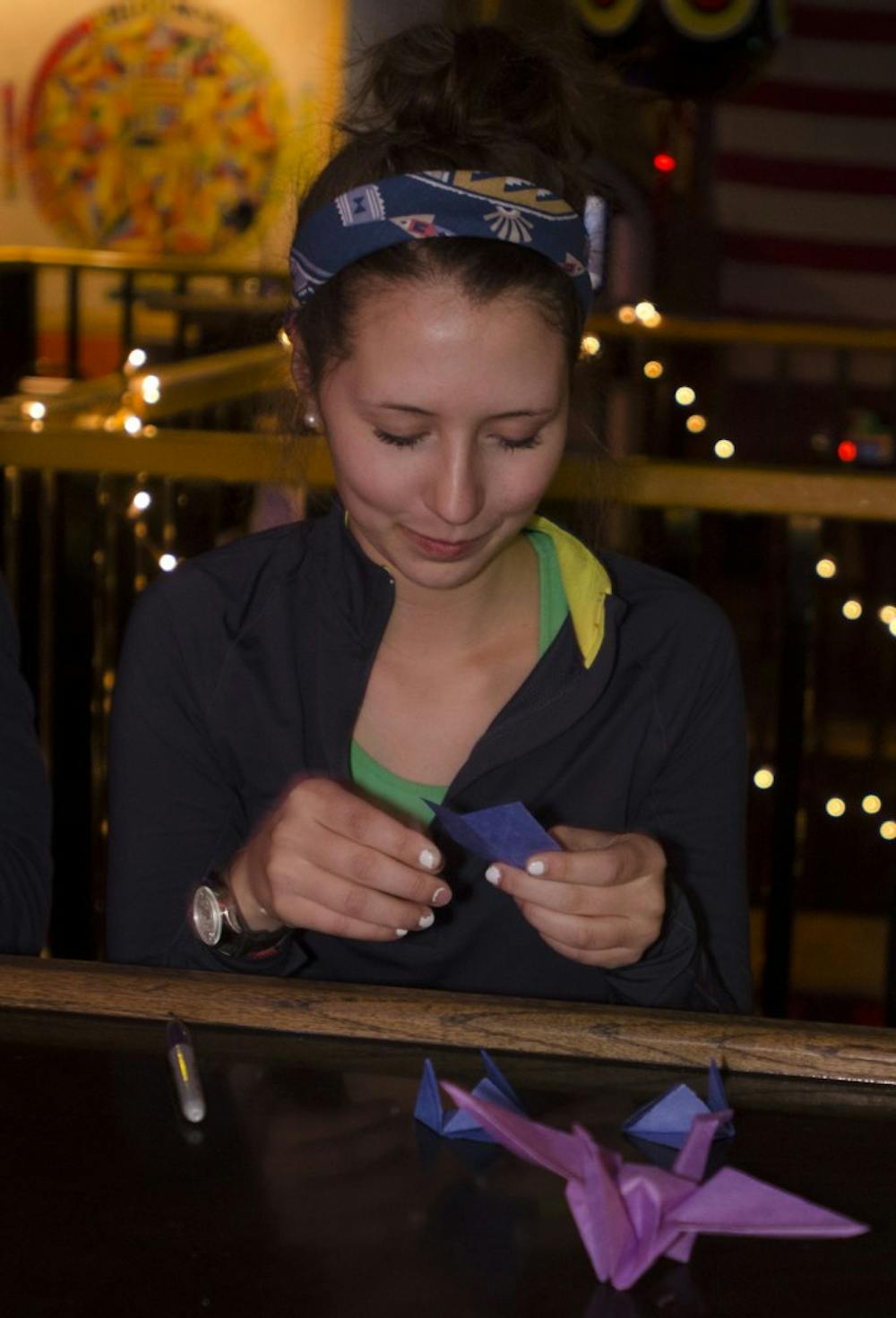 Ball State sophomore Kailey Sullivan, a graphic design major, makes origami at Be Here Now Jan. 22. Participants made origami airplanes with a wish written inside. DN PHOTO MARCEY BURTON