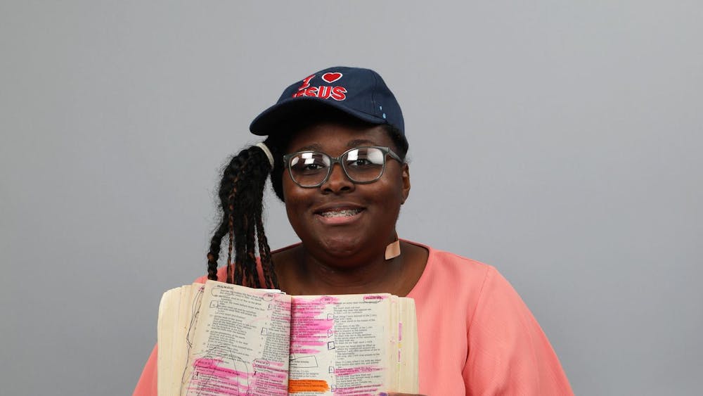 Ball State student Rayanna Herron holds up the Bible while posing for a photo March 1 at the Arts and Journalism Building. Mya Cataline, DN
