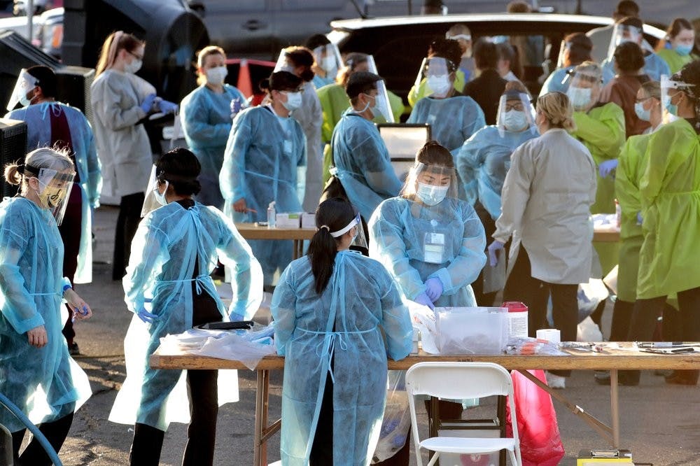 Medical personnel prepare to test hundreds of people lined up in vehicles June 27, 2020, in Phoenix's western neighborhood of Maryvale. PPE is running out again as the number of hospitalized patients climbs. (AP Photo/Matt York, File)