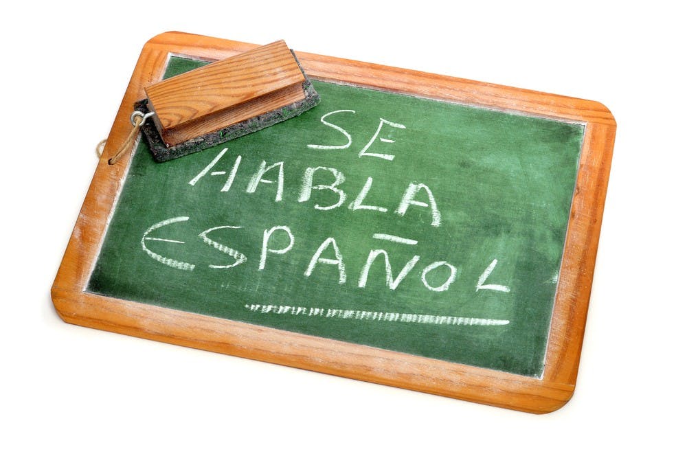 sentence Spanish is spoken written in spanish on a chalkboard
