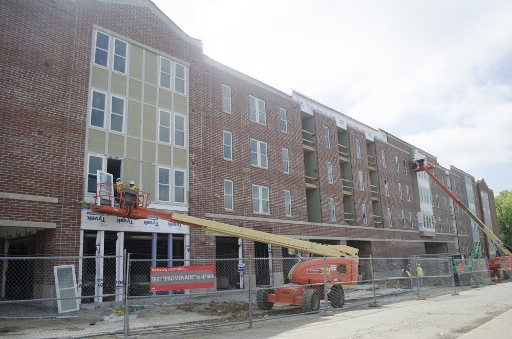 Construction workers put windows in the Village Promenade on June 21. The top two floors of the Village Promenade had mold from rainfall but the company removed it, an official said. DN PHOTO BREANNA DAUGHERTY