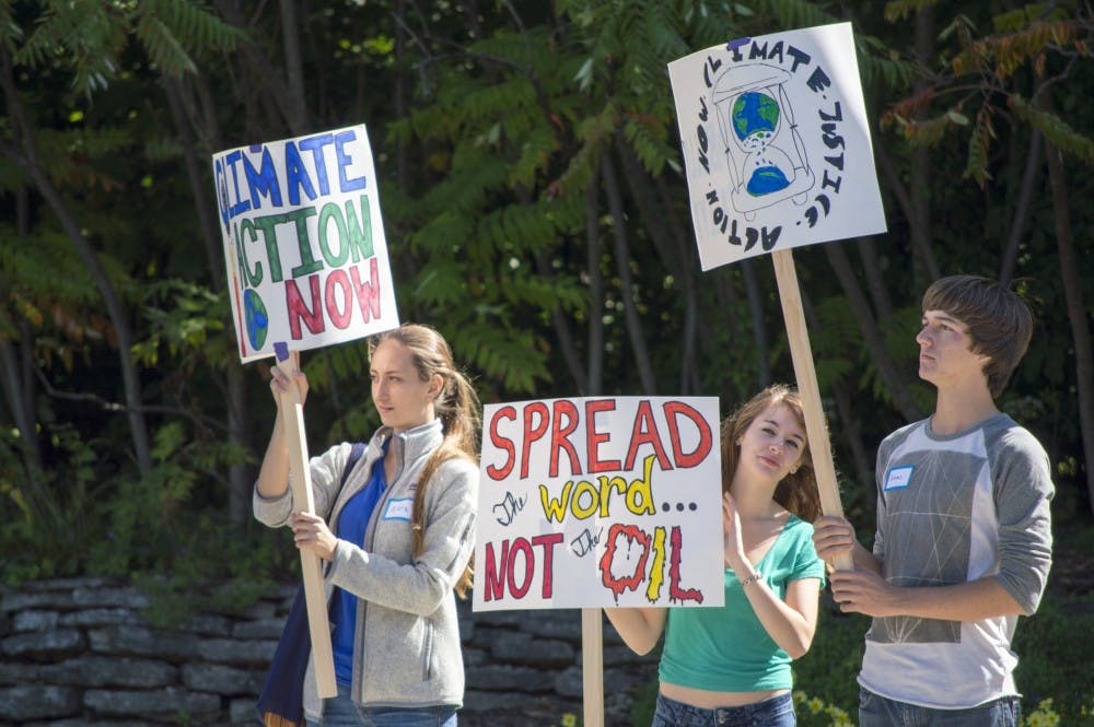 Academy students, Kiara Goodwine, 17, Lyndsie King, 18, and Julian Epp, 17, hold posters at the climate rally on Sept. 21 at Riverside United Methodist Church. DN PHOTO ALAINA JAYE HALSEY