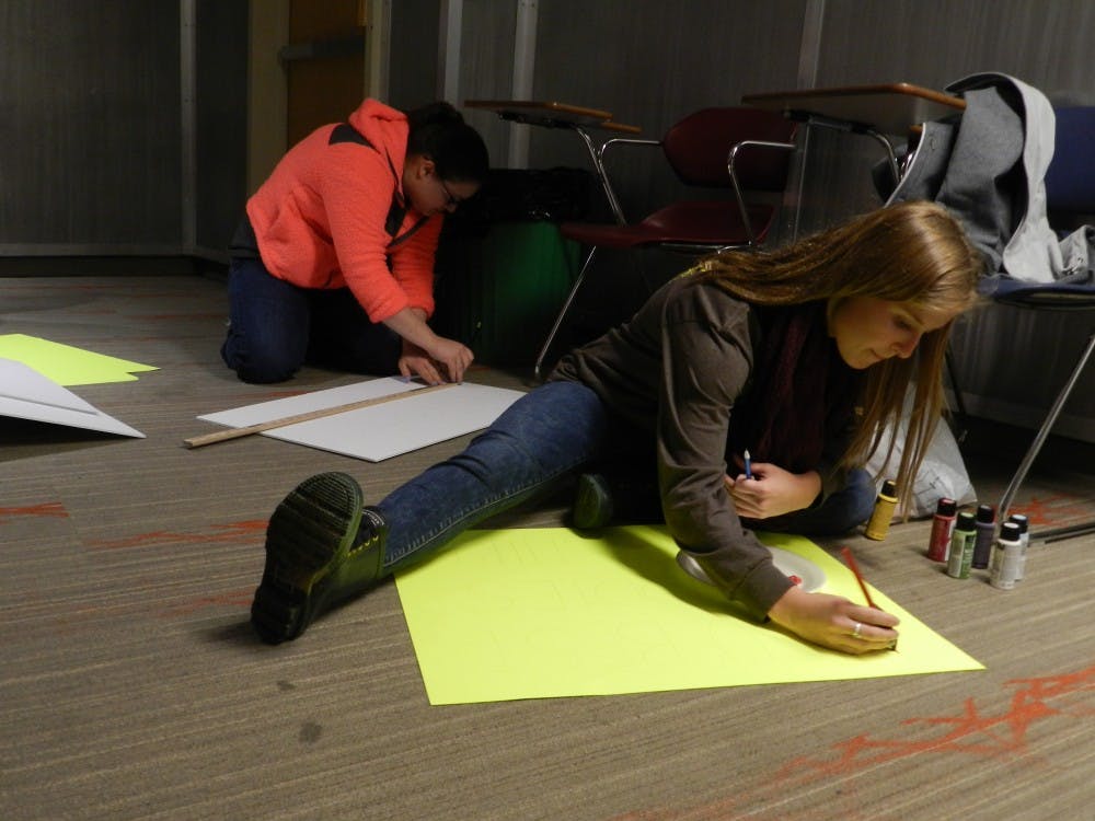 <p>Best Buddies officers work on signs for their upcoming event. The race, #eRacetheRword, will start at Canan Commons on April 3 at 2 p.m. PHOTO BY DESIREE WILLIAMS</p>