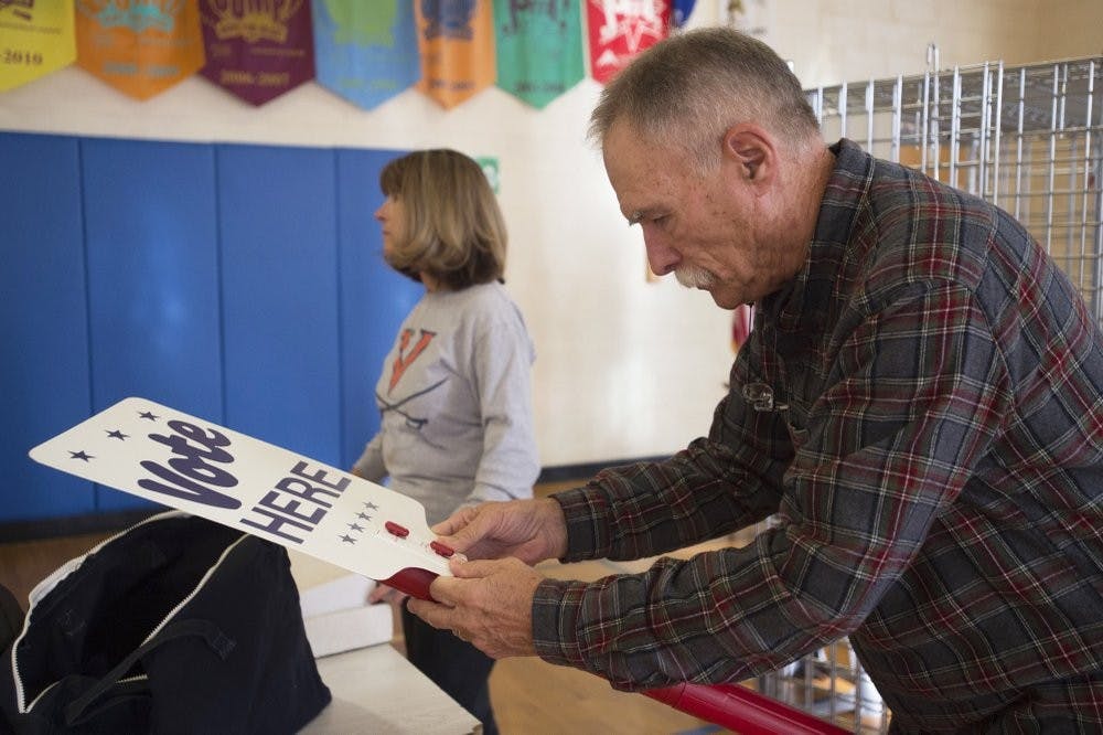 <p>Harry Ford, right, puts together a "vote here" sign at a polling station set up at Boonsboro Elementary School in Bedford, Va., Monday, Nov. 4, 2019. Several people helped set up the polling station in preparation for election day Tuesday. <strong>(Taylor Irby/The News &amp; Advance via AP)</strong></p>