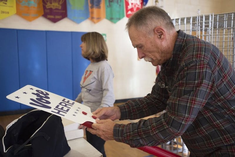 Harry Ford, right, puts together a "vote here" sign at a polling station set up at Boonsboro Elementary School in Bedford, Va., Monday, Nov. 4, 2019. Several people helped set up the polling station in preparation for election day Tuesday. (Taylor Irby/The News &amp; Advance via AP)