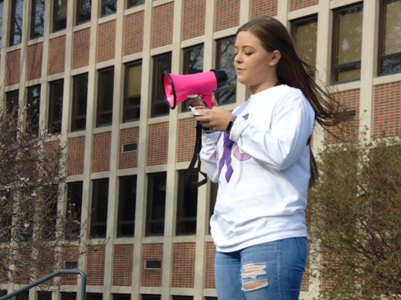 Sara Leatherberry, philanthropy chair for Alpha Chi Omega, reads off sexual assault statistics during the candlelight vigil April 16, 2019, at "Take Back the Night 2019." The on-campus event helped raise awareness on domestic violence and sexual assault. Evan Weaver, DN