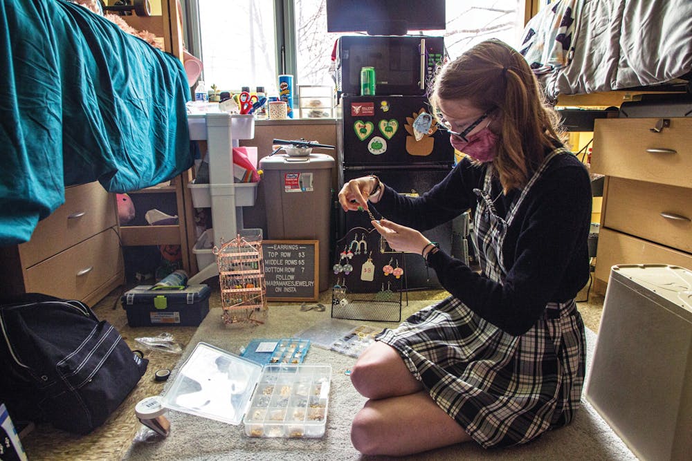 Freshman psychology major Maiya Garcia assembles an earring for her jewelry business, Maiya Makes Jewelry, April 9, 2021 in her dorm room at DeHority Complex. Out of all the pieces of jewelry she makes, Garcia sells earrings the most. Nicole Thomas, DN