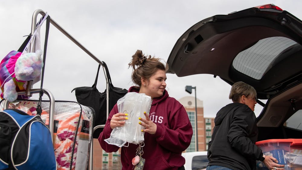 Senior exercise student Danielle Sprouse takes her stuff from the cart to her mom's car March 17, 2020, outside of Park Hall. Multiple students and their families were moving out of all the dorms. Jacob Musselman, DN