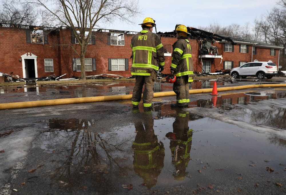<p>Members of the Muncie Fire Department stand in front of a burned building Feb. 16 at the Colonial Creek Apartments on Morrison Road. Rylan Capper, DN </p>