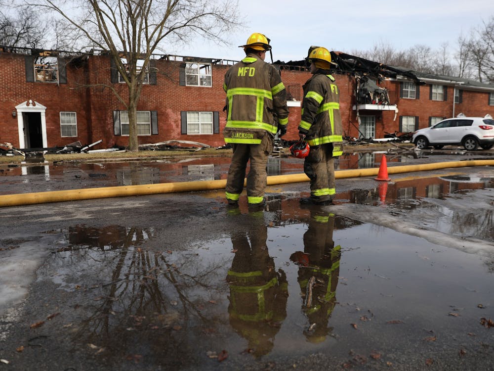Members of the Muncie Fire Department stand in front of a burned building Feb. 16 at the Colonial Creek Apartments on Morrison Road. Rylan Capper, DN 