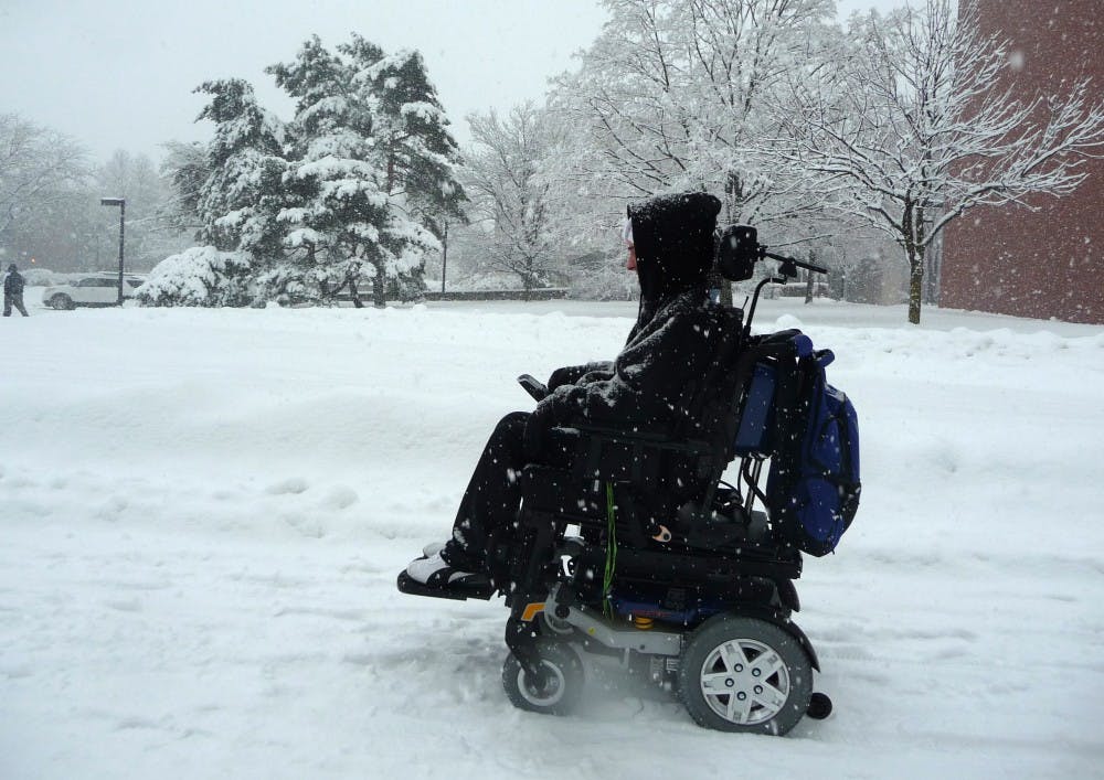 Colin McIntire, a junior computer science major, passes Bracken Library in the snow. McIntire said he had trouble crossing McKinley Avenue, but doesn
