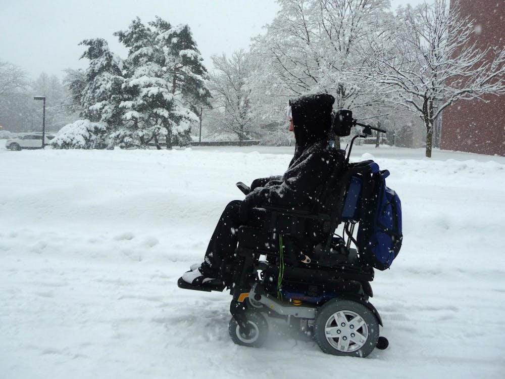 Colin McIntire, a junior computer science major, passes Bracken Library in the snow. McIntire said he had trouble crossing McKinley Avenue, but doesn