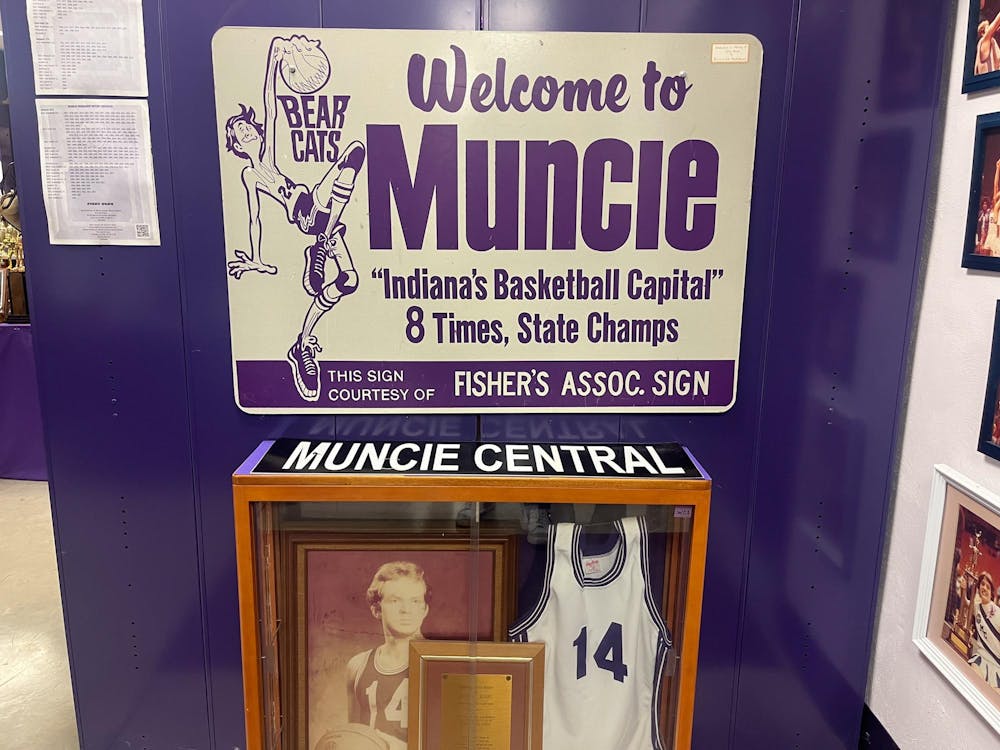 A sign showcasing the history of Muncie Central boys' basketball hangs in the memorabilia room of the Muncie Fieldhouse March 25. Below the sign is a small case filled with artifacts from Muncie Central alumni Jack Moore. Kyle Smedley, DN