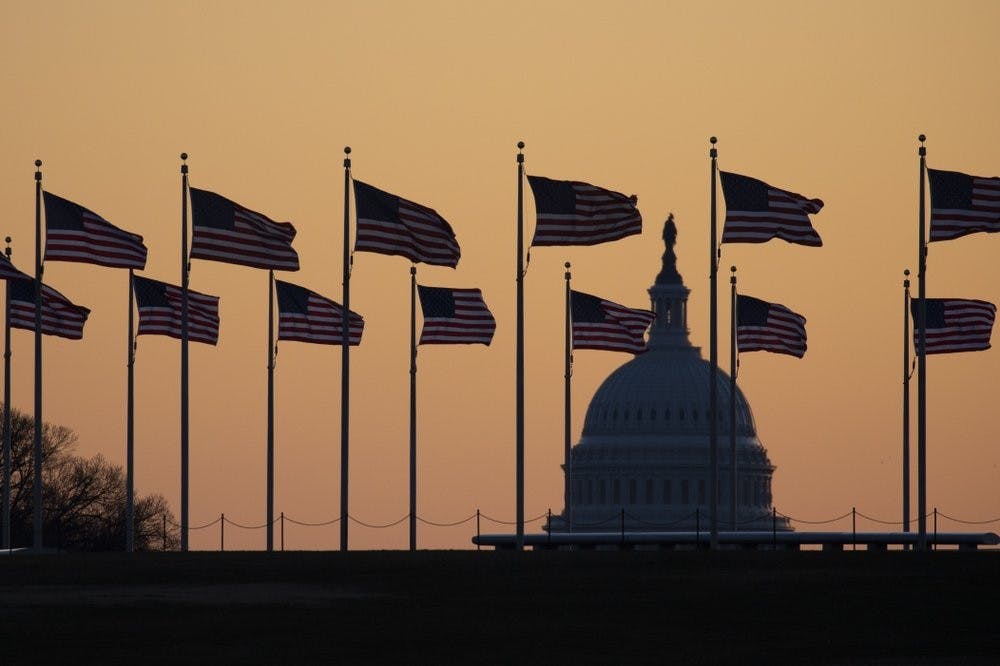 <p>American flags blow in wind around the Washington Monument with the U.S. Capitol in the background at sunrise Jan. 20, 2020, in Washington. The impeachment trial of President Donald Trump will resume in the U.S. Senate on Jan. 21. <strong>(AP Photo/Jon Elswick)</strong></p>