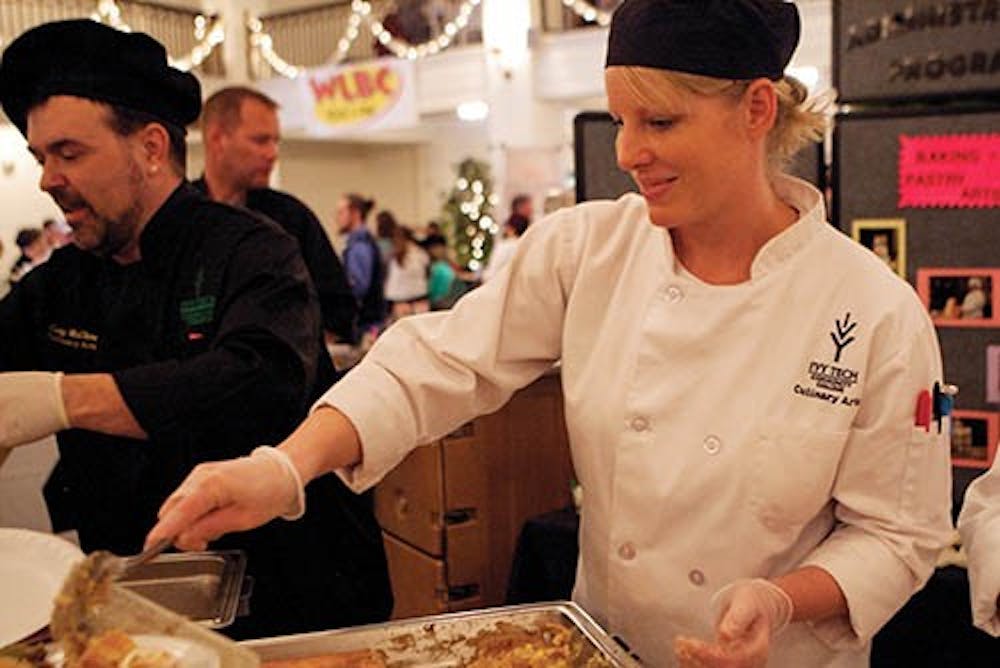 <p>Ivy Tech student Alisha Mosier serves a dish made by students during the annual Taste of Muncie on April 21, 2013. Twenty-two organizations had booths with food for tasting at the Cornerstone Center of the Arts building downtown. <strong>Jordan Huffer, DN File</strong></p>