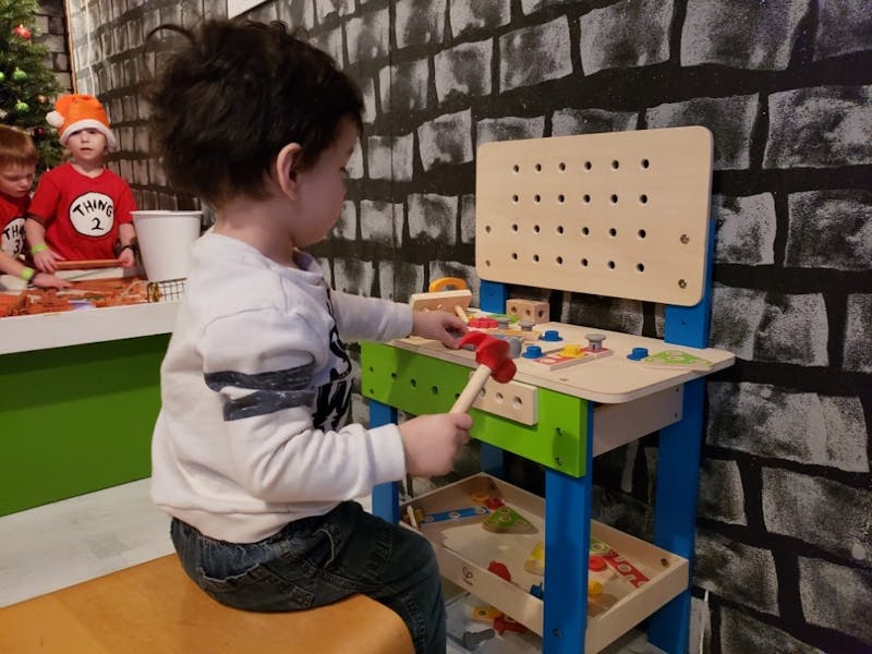 Two-year-old Levi Miller works for his Elf license by building toys in Santa's Workshop Dec. 15, 2018, at the Muncie Children's Museum. Santa's workshop is the third to last stop for in-training elves. Scott Fleener, DN