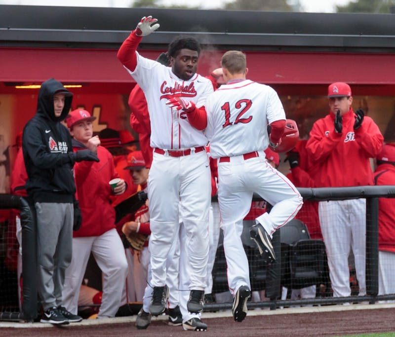 Freshman outfielder Joe Gunn celebrates with his teammates after a score during the game against Dayton at the Ball Baseball Diamond on March 18. The Cardinals hosted a double header for this season's home opener and won both games. The Cardinals won 6-0 in the first game and 4-3 in the second game. &nbsp;Kyle Crawford, DN