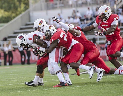 Sophomore Jordan Williams makes a drive down the field, despite being actively tackled by members of the Illinois State line. Williams caught six passes and had 64 receiving yards during the game Thursday. DN PHOTO CORY OHLENKAMP