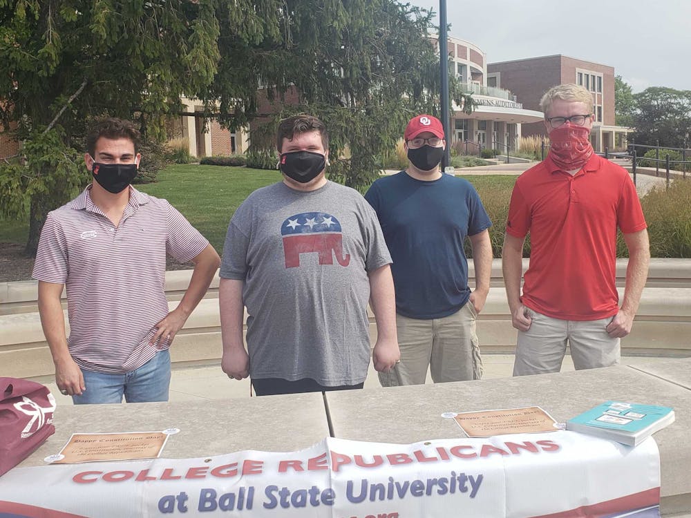 Dylan Lewandowski, Chase Braden, Jacob Knapp and Gaven Schulz distribute pocket U.S. Constitutions at the Scramble Light Sept. 17, 2020. The Ball State College Republicans and the College Democrats have each been involved in outreach projects to register students to vote. Jaden Hasse, DN