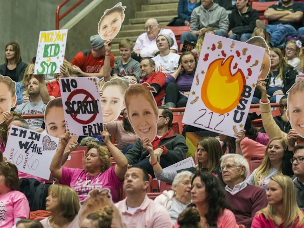 Fans holding up signs at Ball State gymnastics quad-meet on Feb. 14 at Worthen Arena. 