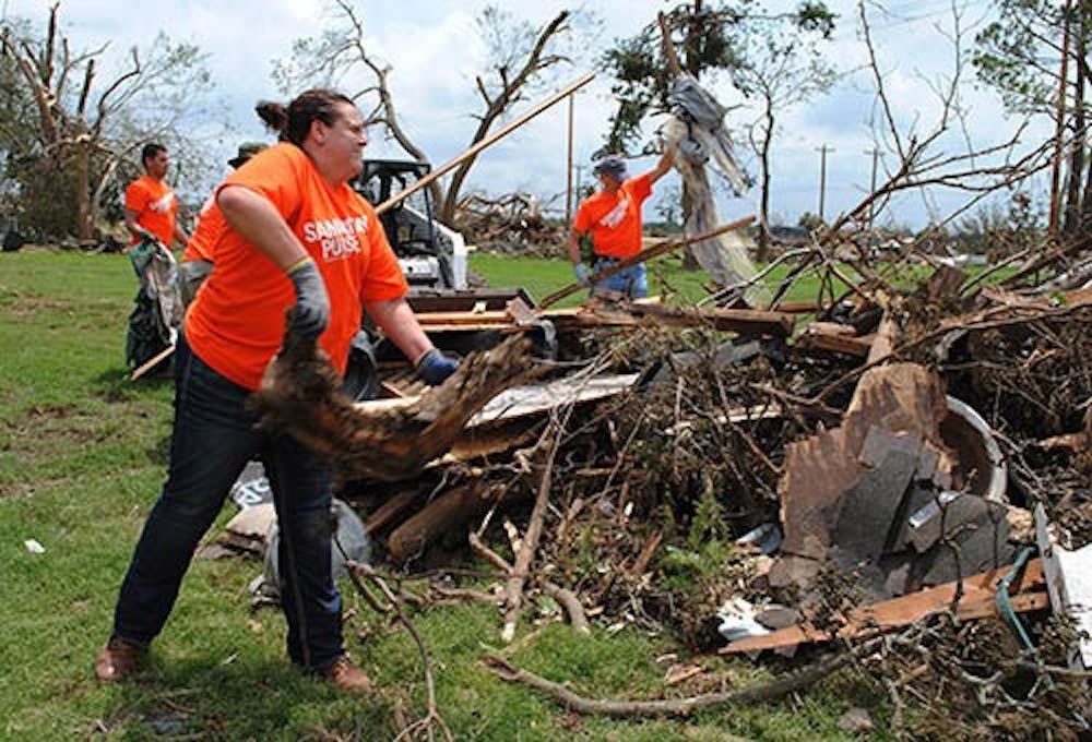Stephanie Houk, of Waukesha, carries tree limbs while cleaning up, May 26, 2013 in Moore, Okl. Houk was one of many volunteers who was helping clean up after storms that effected communes in Oklahoma. MCT PHOTO 