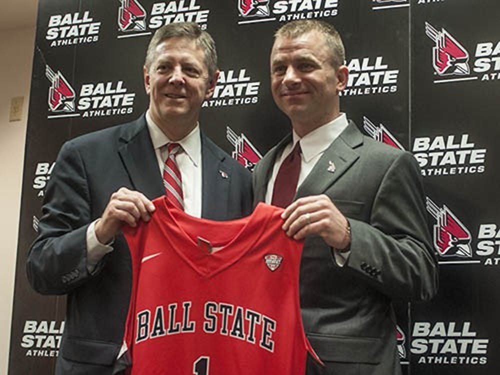 Athletic director Bill Scholl and men's basketball head coach James Whitford pose for a photo holding an honorary jersey given to Whitford. Whitford was named head coach to replace Billy Taylor for the 2013-14 season. DN PHOTO JONATHAN MIKSANEK