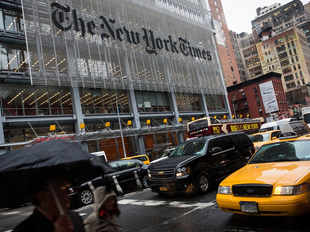 People walk past The New York Times building on Oct. 1, 2014, in New York City. The Times announced plans to cut approximately 100 jobs from the newsroom today, with the company announcing it will start with buy-out packages before moving to layoffs. (Andrew Burton/Getty Images/TNS)